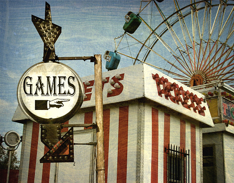 aged and worn games sign at carnival