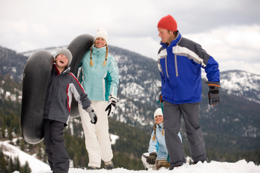 A smiling family heads out for a day of sledding. photo