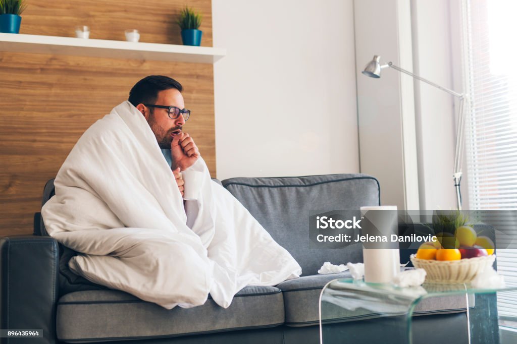 Suffering from cold Young man suffering from cold and coughing Cold And Flu Stock Photo