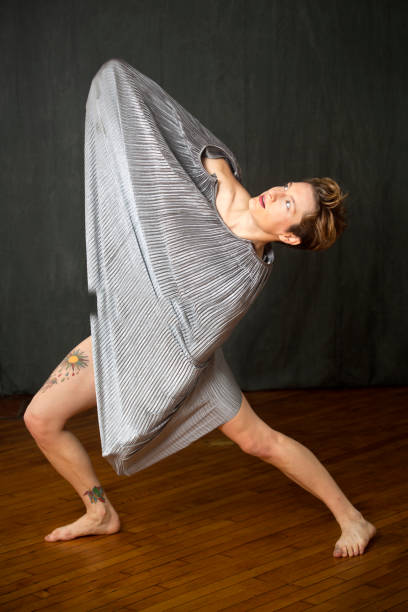istock Young woman in silver dress dancing in the studio. 896441756