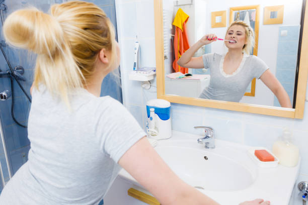 istock Woman brushing cleaning teeth in bathroom 896442222