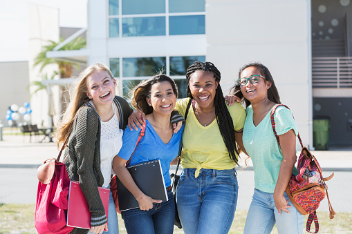 Cuatro estudiantes adolescentes multiétnicos en el campus photo