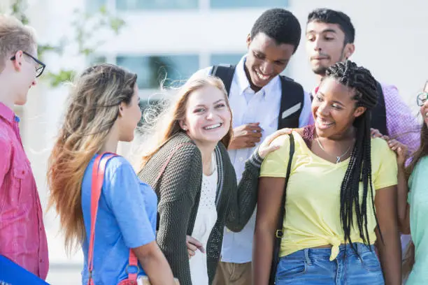 Photo of Teenage girl with multi-ethnic friends outside school