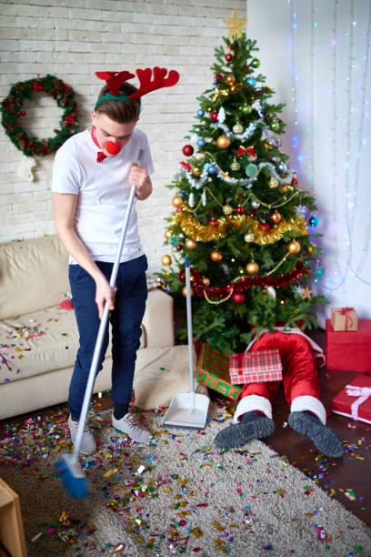 istock Optimistic guy cleaning room after Christmas party 896458300