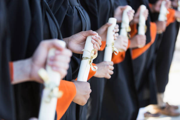 istock Multi-ethnic teenage graduates in cap and gown 896458406