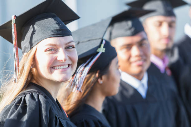 istock Multi-ethnic teenage graduates in cap and gown 896458438