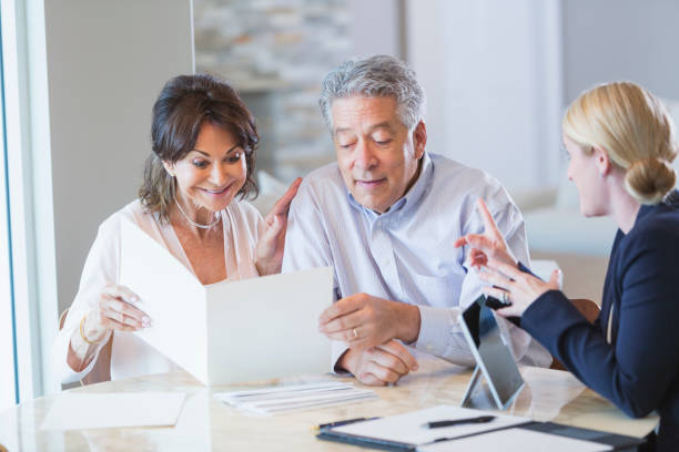 istock Senior couple talking with financial advisor, reading brochure 896458640
