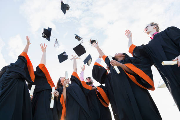 istock Multi-ethnic teenage graduates throw caps in air 896458688