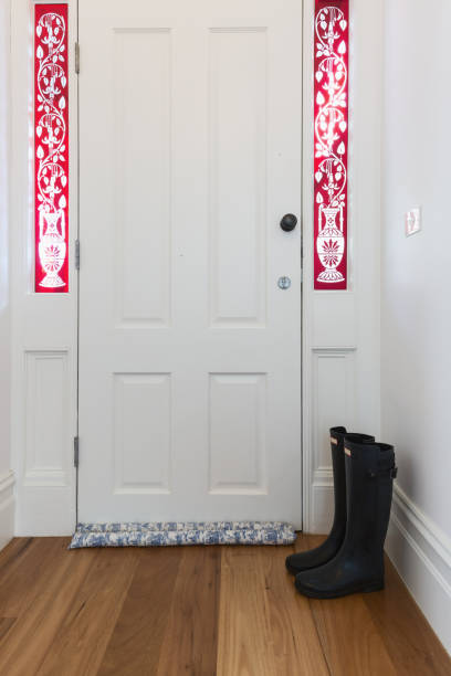istock Inside view of front door with leadlight windows and a pair of boots 896458858