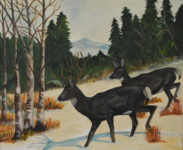 Two deer walk down the side of a snowy hill in the mountains in winter.