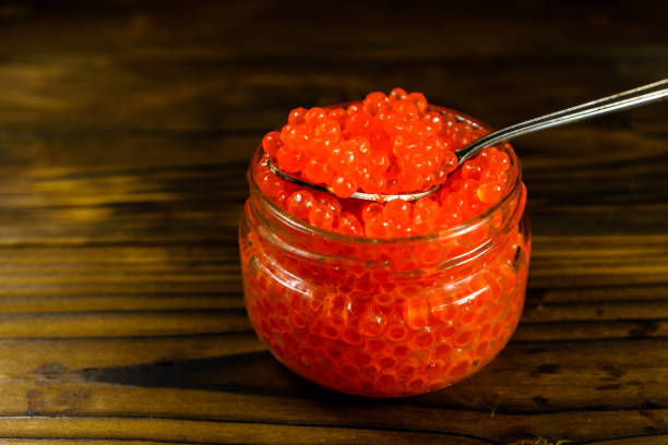 istock Red caviar in a spoon above the glass jar 896489782