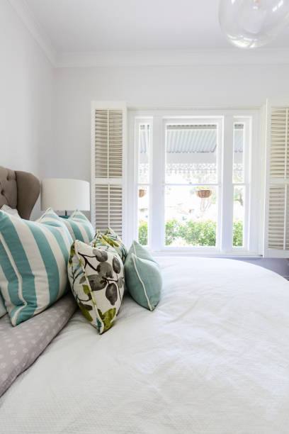 istock White shutters and blue fabric cushions in a beautiful bedroom interior 896519194