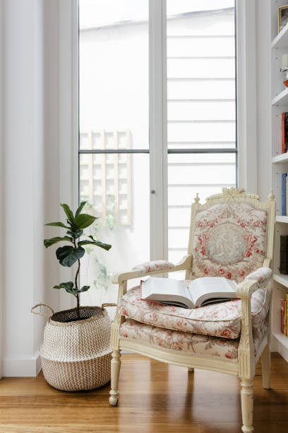 Open book on a comfotable vintage reading chair in a renovated home Open book on a comfotable vintage reading chair in a renovated home nook architecture photos stock pictures, royalty-free photos & images
