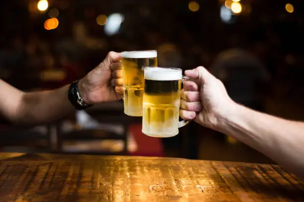 Toast with iced beer mugs on the bar counter.