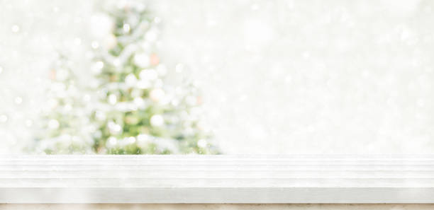 istock Empty white wooden table top with abstract muted blur christmas tree and snow fall background with bokeh light,Holiday backdrop,Mock up banner for display or montage of product 896560934