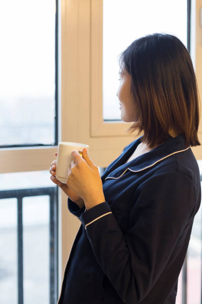 istock attractive woman standing on balcony drinking water after getting up 896586890
