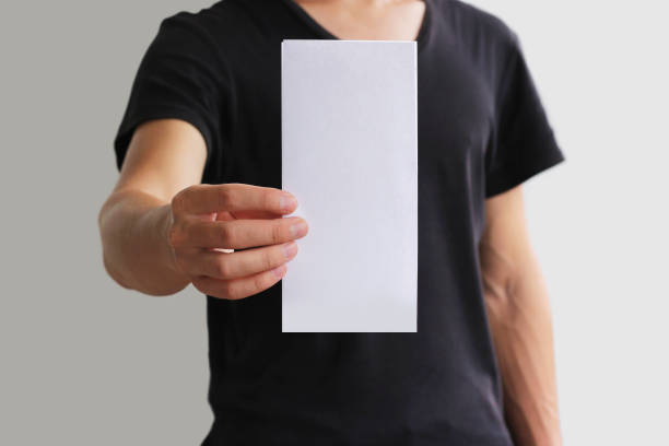 istock Man showing blank white flyer brochure booklet. Leaflet presentation. Pamphlet hold hands. Man show clear offset paper. Sheet template. Booklet design sheet display read first person 896608484
