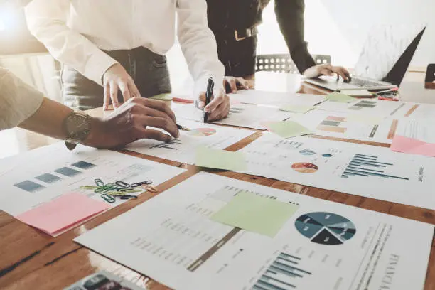 Photo of Business People Analyzing Statistics Business Documents,  Financial Concept