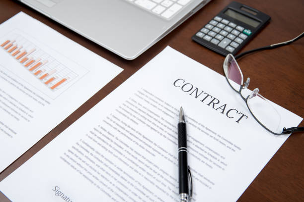 istock Business concepts with contract, notebook, glasses, calculators, and graphs on the desk.  Defocused 896614122