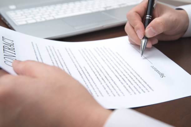 istock A concept of signing a contract holding a pen.  Defocused 896616162