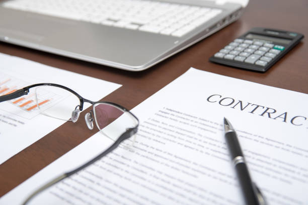 istock Business concepts with contract, notebook, glasses, calculators, and graphs on the desk.  Defocused 896618200