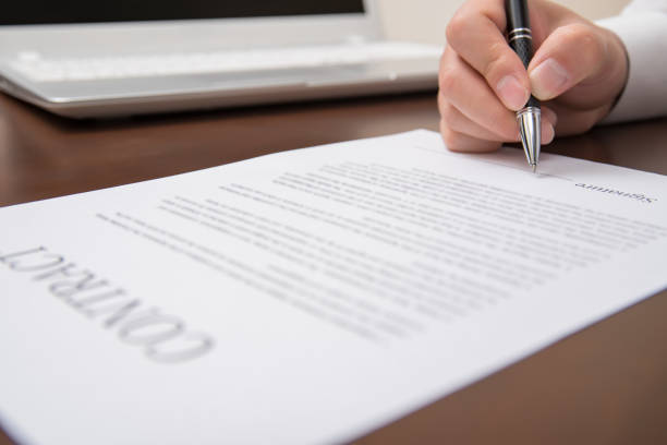 istock A concept of signing a contract holding a pen.   Defocused 896618260