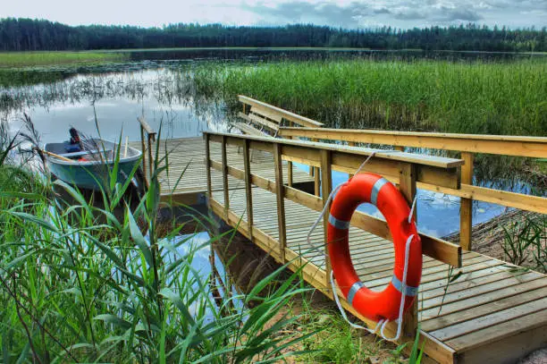 boat with a wooden pier with a lifeline in the reeds on the lake