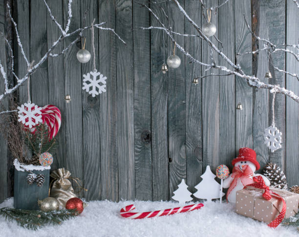 istock Christmas interior with snowman, decorative branches, presents and candy canes on wooden planks background. 896646892