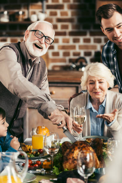 istock family cutting thanksgiving turkey 896654550