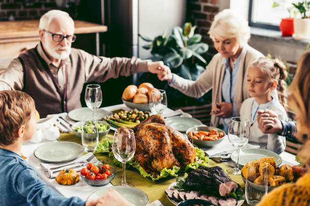 istock family holding hands and praying on thanksgiving 896665352