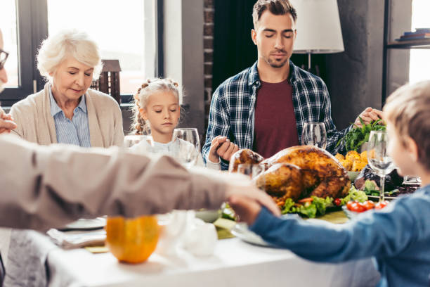 istock family holding hands and praying on thanksgiving 896667388