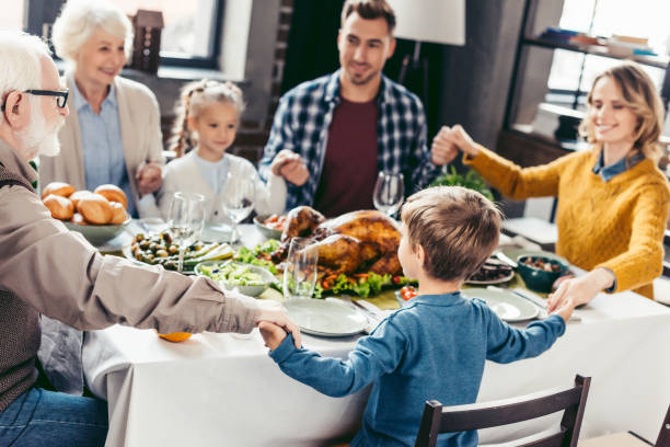 istock family praying before holiday dinner 896667866