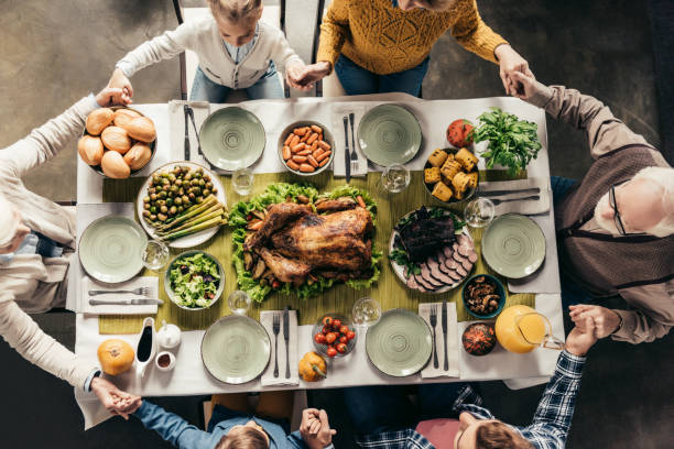 istock family praying before holiday dinner 896669964