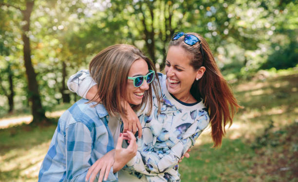istock Happy women embracing and laughing over nature background 896682938