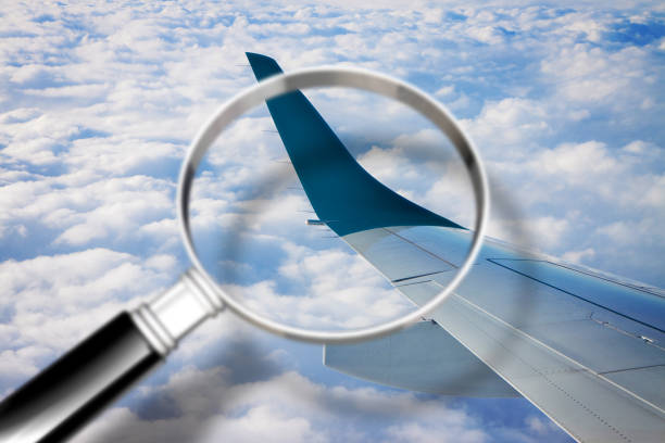 istock Airplane wing above the clouds - surveillance concept image with magnifying glass 896683212
