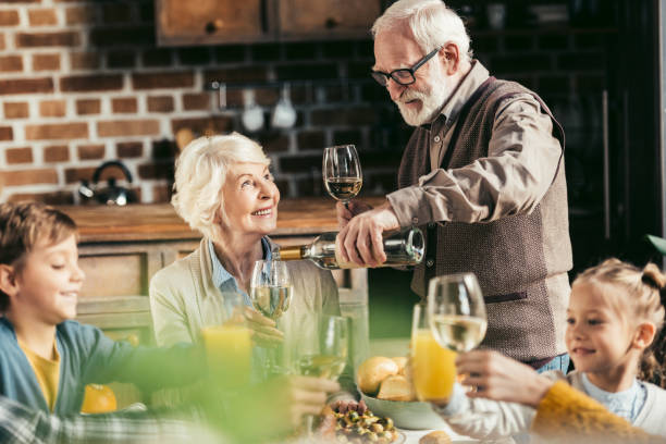 istock senior man pouring wine for woman 896690296