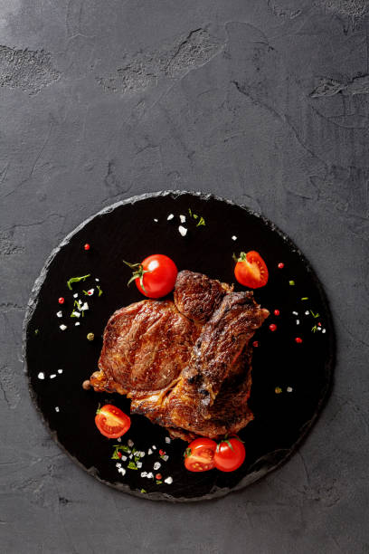 istock Rare rib eye steak on dark plate, top view 896693084