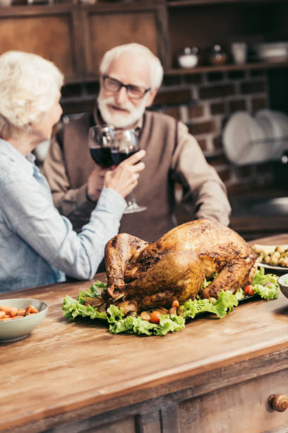 istock senior couple clinking glasses on thanksgiving 896697908
