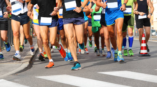 istock runners run at finish line during race in the city 896715384