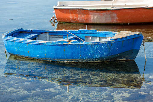 Old blue wooden rowing boat moored in the port. Marzamemi, Syracuse (Siracusa) - Sicily island, Italy