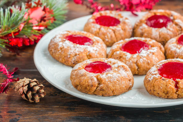 biscotti di natale tradizionali tedeschi engelsaugen con marmellata di bacche rosse su un piatto bianco sul tavolo di legno - marmalade baked biscuit brown foto e immagini stock