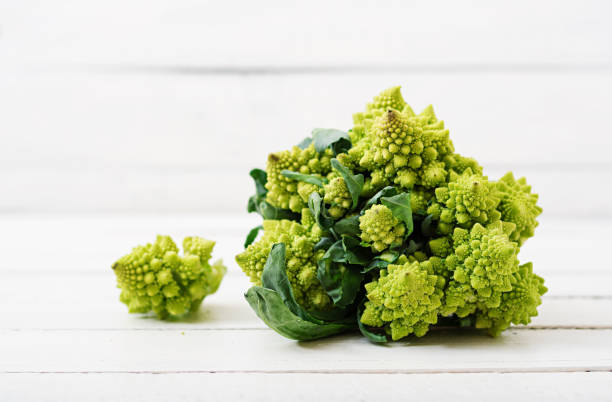 romanesco kohl auf weißem hintergrund - romanesque broccoli cauliflower cabbage stock-fotos und bilder