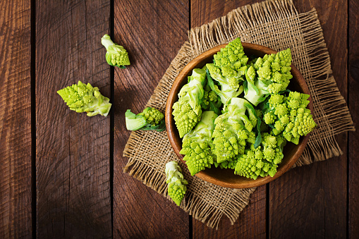 Cabbage romanesco on a dark wooden background. Top view