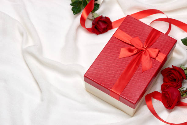 istock Red gift box with ribbon bow present and red roses on holiday 896734966