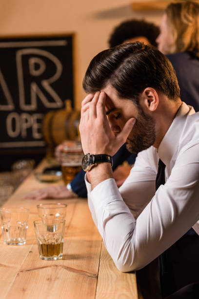 istock businessman drinking whisky in bar 896742416