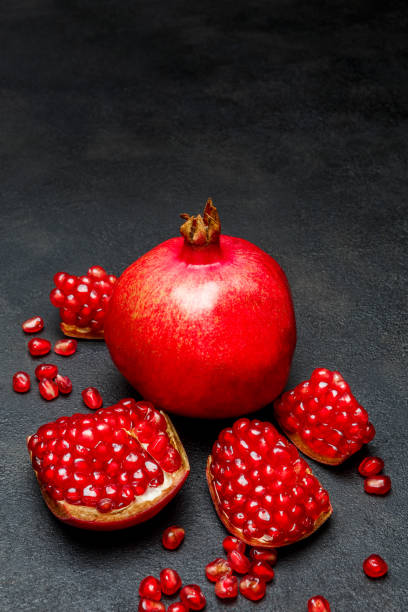 istock Pomegranate and seeds close-up on dark concrete background 896760828