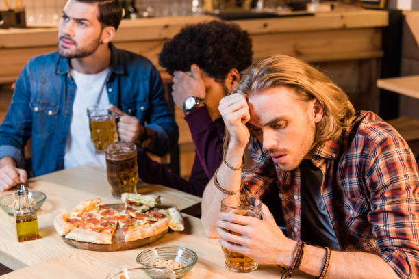 istock friends with pizza and beer in bar 896761808