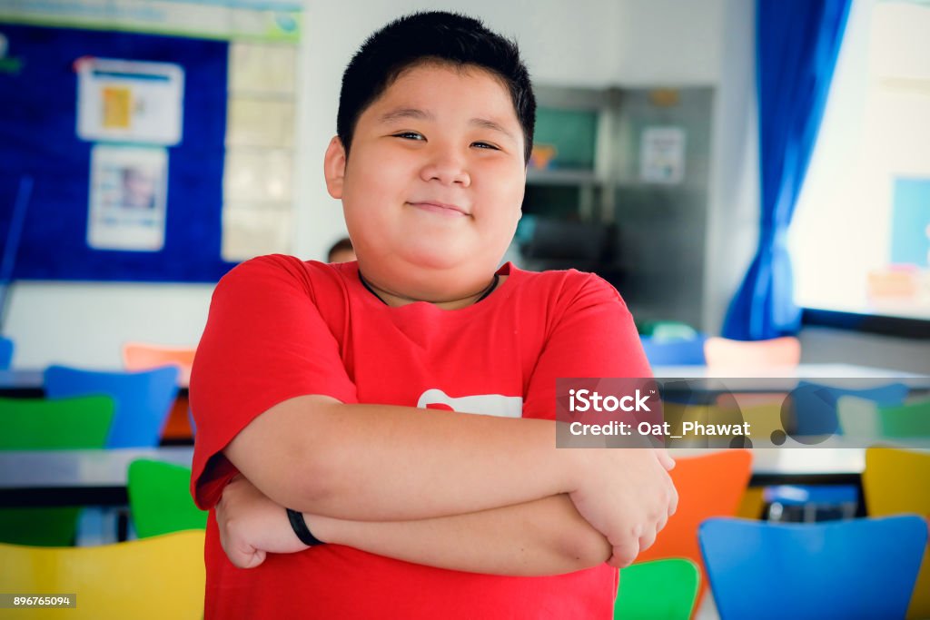 Asian obese boy standing crossed arms and cute smile Overweight Stock Photo