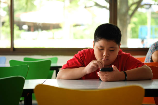 asian child boy are addictive playing tablet and mobile phones, game addiction - adipose cell imagens e fotografias de stock