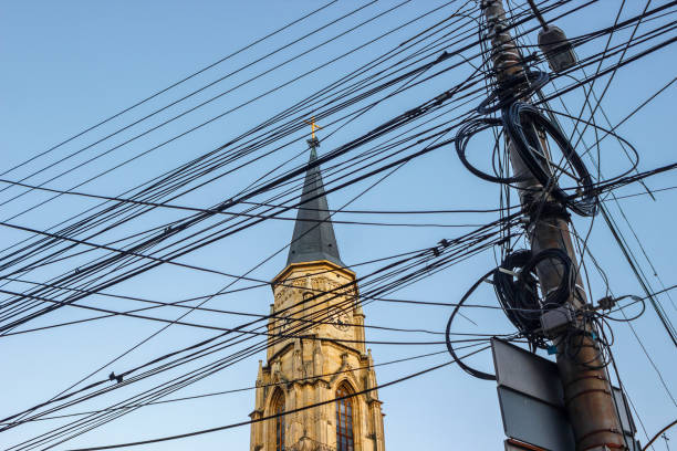 Messy electrical cables in front of the St. Michael's Church in Cluj-Napoca, Romania. Uncovered optical fiber technology open air outdoors in European city centre